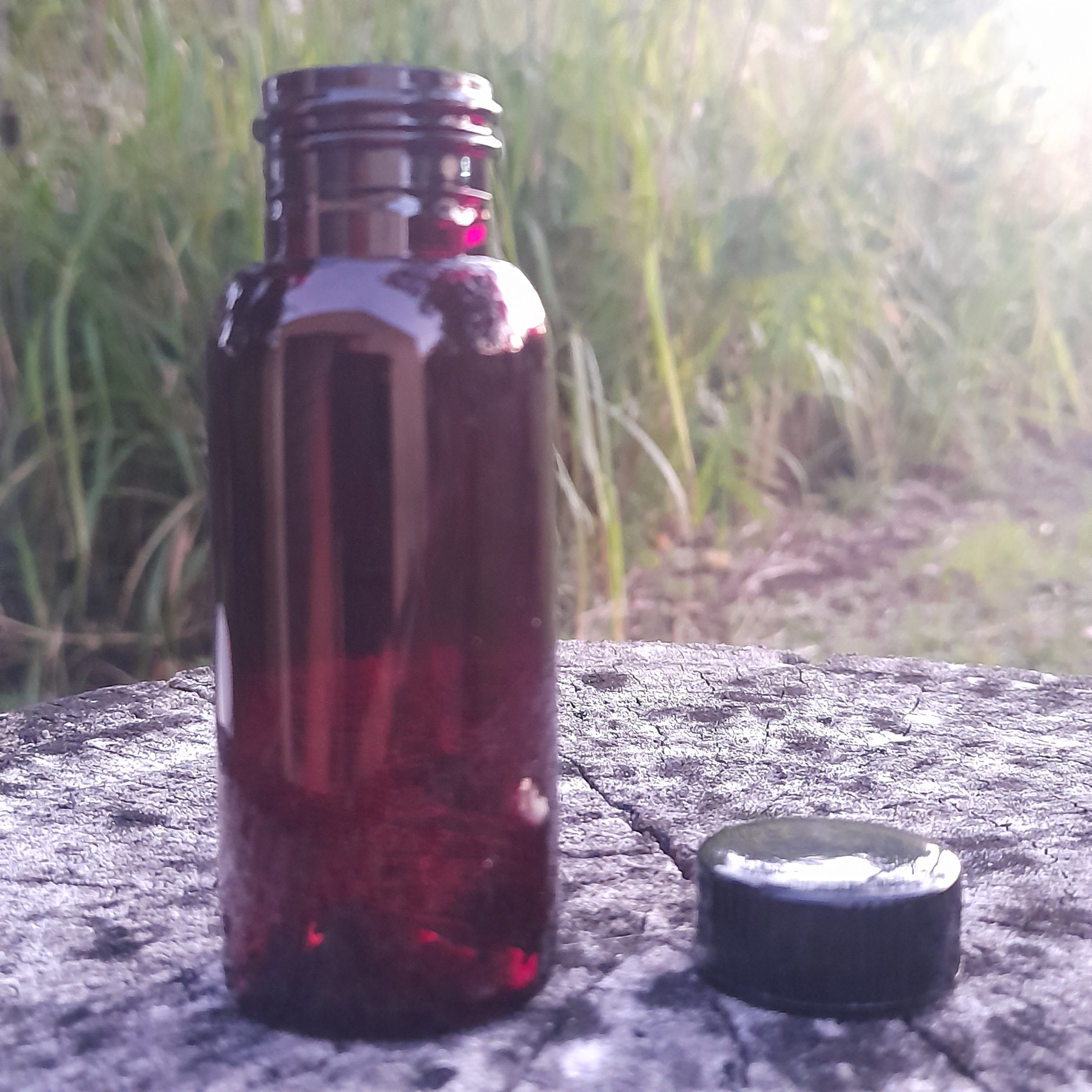 Empty amber PET 50ml travel bottle with plain black cap 24mm neck